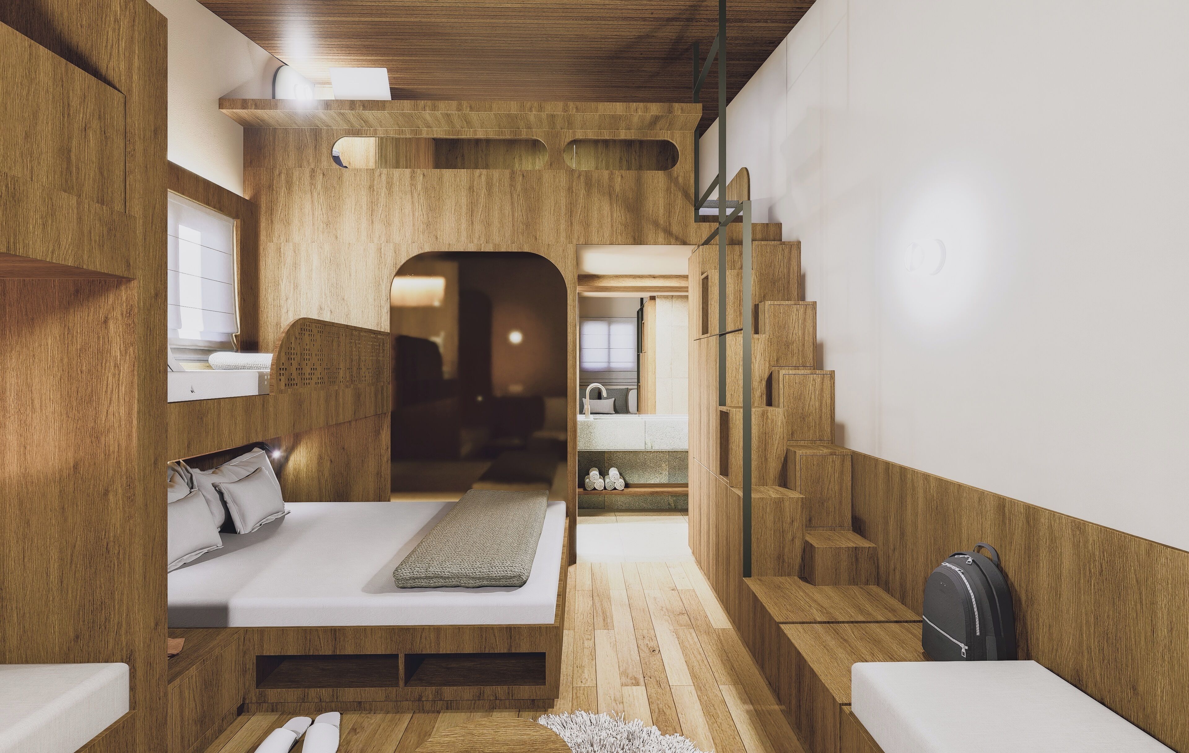Un dormitorio moderno y compacto con muebles de madera integrados, una cama con almohadas, un pequeño rincón de descanso y una escalera que lleva a un nivel superior.