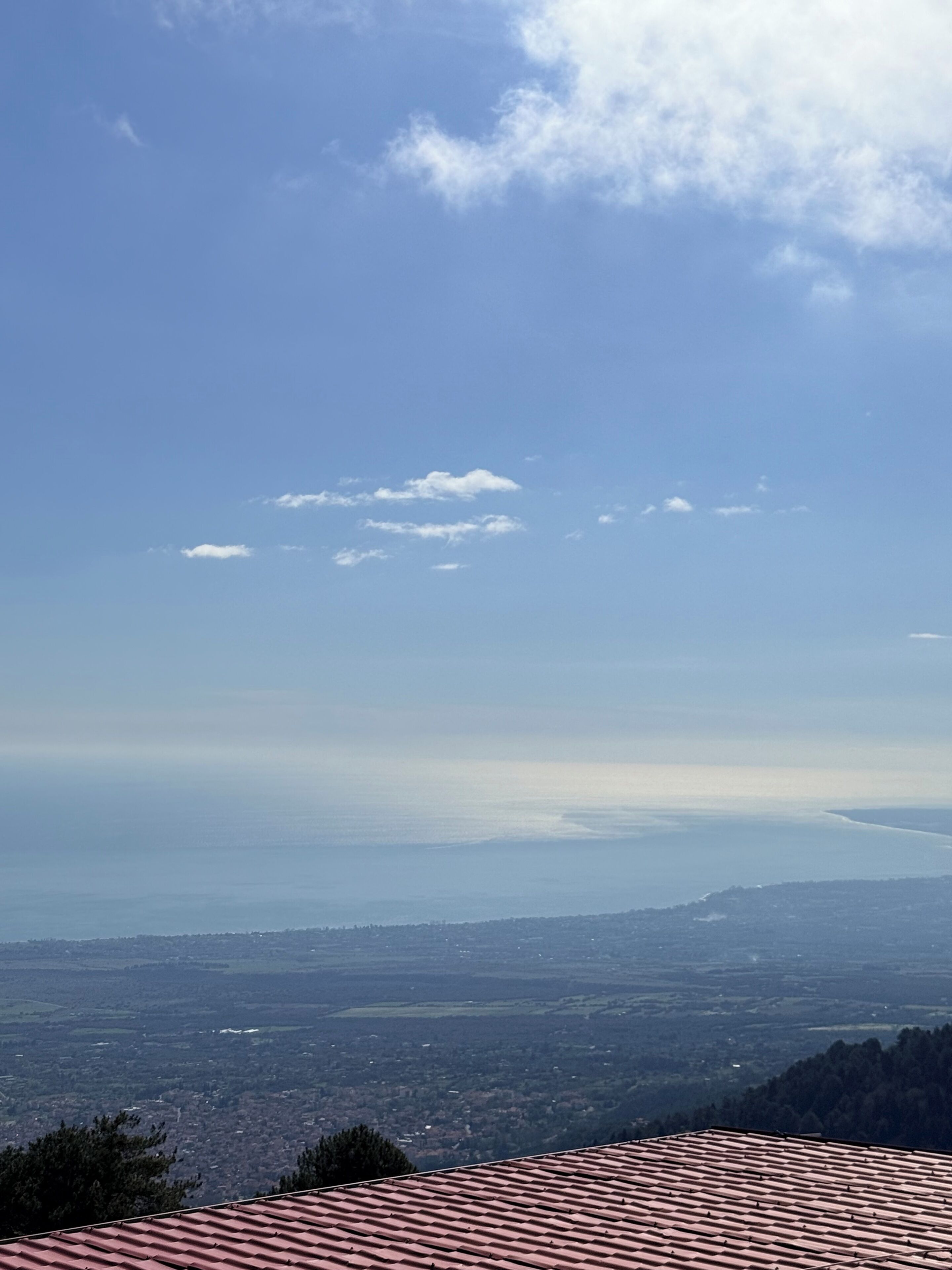 Vista panoràmica d'una ciutat des d'un punt elevat, amb teulades vermelles i les colines a la distància.