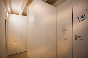 A hotel room with a wardrobe, a bedside telephone, and a door with a handle and lock. - Accogliente Loft Bijoux a Verona (Verona)