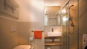 Un baño moderno con inodoro, lavabo y ducha.