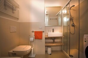 Ein modernes Badezimmer mit Toilette, Waschbecken und Dusche.