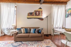 A cozy living room with a brown sofa, patterned rug, and a painting on the wall. - Maison Riva 12 Verona (Verona)