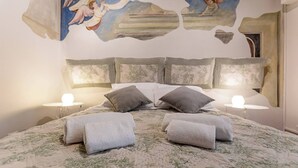 A hotel room with a bed, pillows, and a painting on the wall. - Maison Riva 12 Verona (Verona)