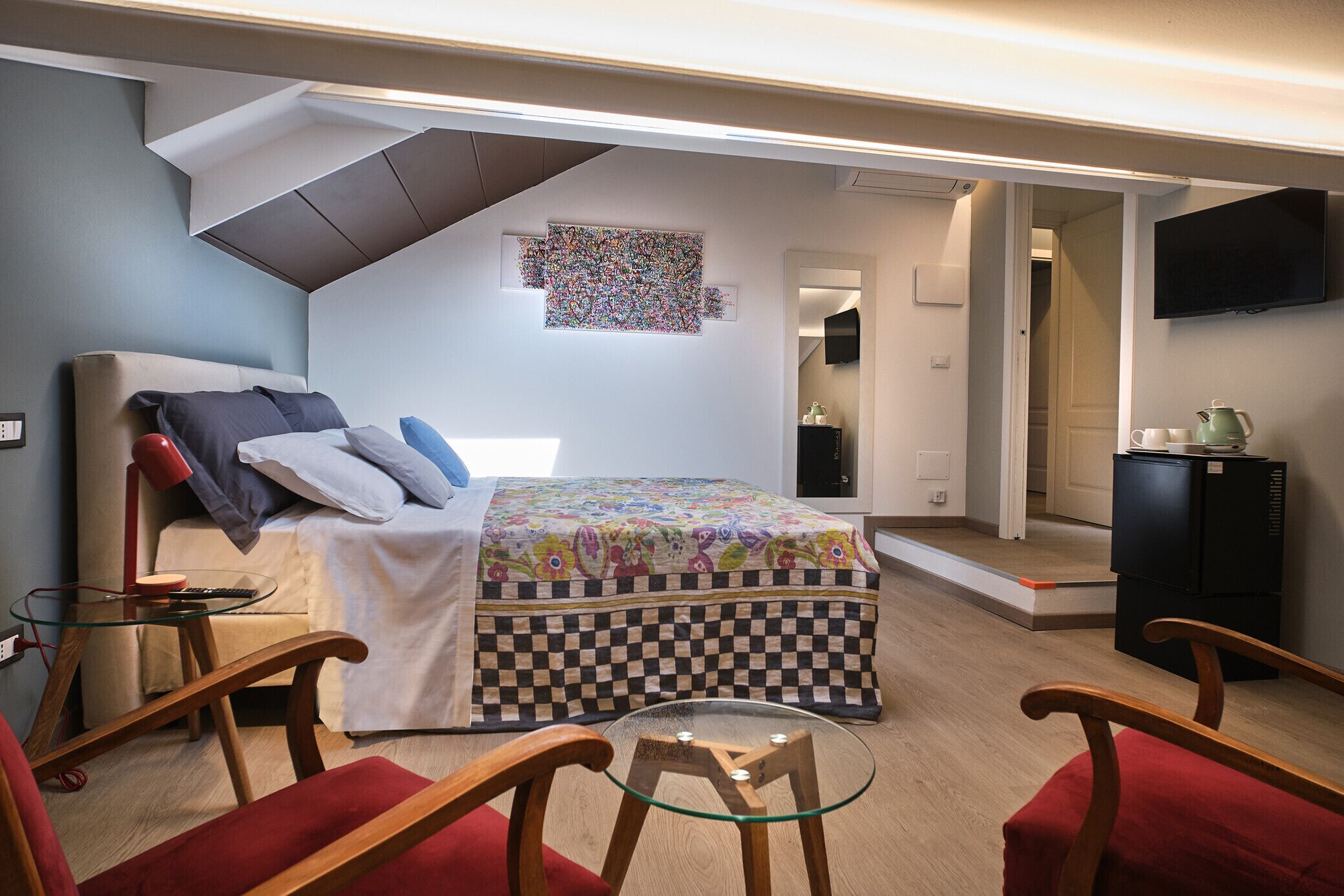 A compact bedroom with a bed, a desk, and a chair.