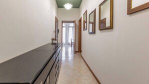 A hallway with a long counter, a ceiling light fixture, and a door leading to another room. - Stanza con bagno privato 9 - uso cucina Bastioni (Verona)