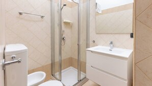 A modern bathroom with a glass-enclosed shower, a toilet, a bidet, and a sink with a mirror above it. - Stanza con bagno privato 9 - uso cucina Bastioni (Verona)