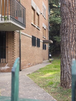 A brick building with a balcony, a tree, and a paved walkway. - Accogliente CASA DIONIGI a Verona (Verona)