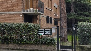 A multi-story brick building with balconies, a tree in front, and a gate with a sign. - Accogliente CASA DIONIGI a Verona (Verona)