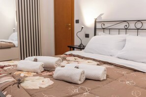 A hotel room with a bed, a nightstand, a lamp, and a door. - -Stanza con bagno privato 8 - uso cucina -Bastioni (Verona)