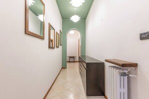 A hallway with a radiator, a wooden counter, and a bench. - -Stanza con bagno privato 8 - uso cucina -Bastioni (Verona)