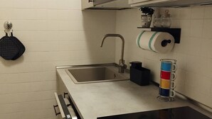 A compact kitchen with a sink, stove, and oven. - Appartamento La Sosta (Verona)