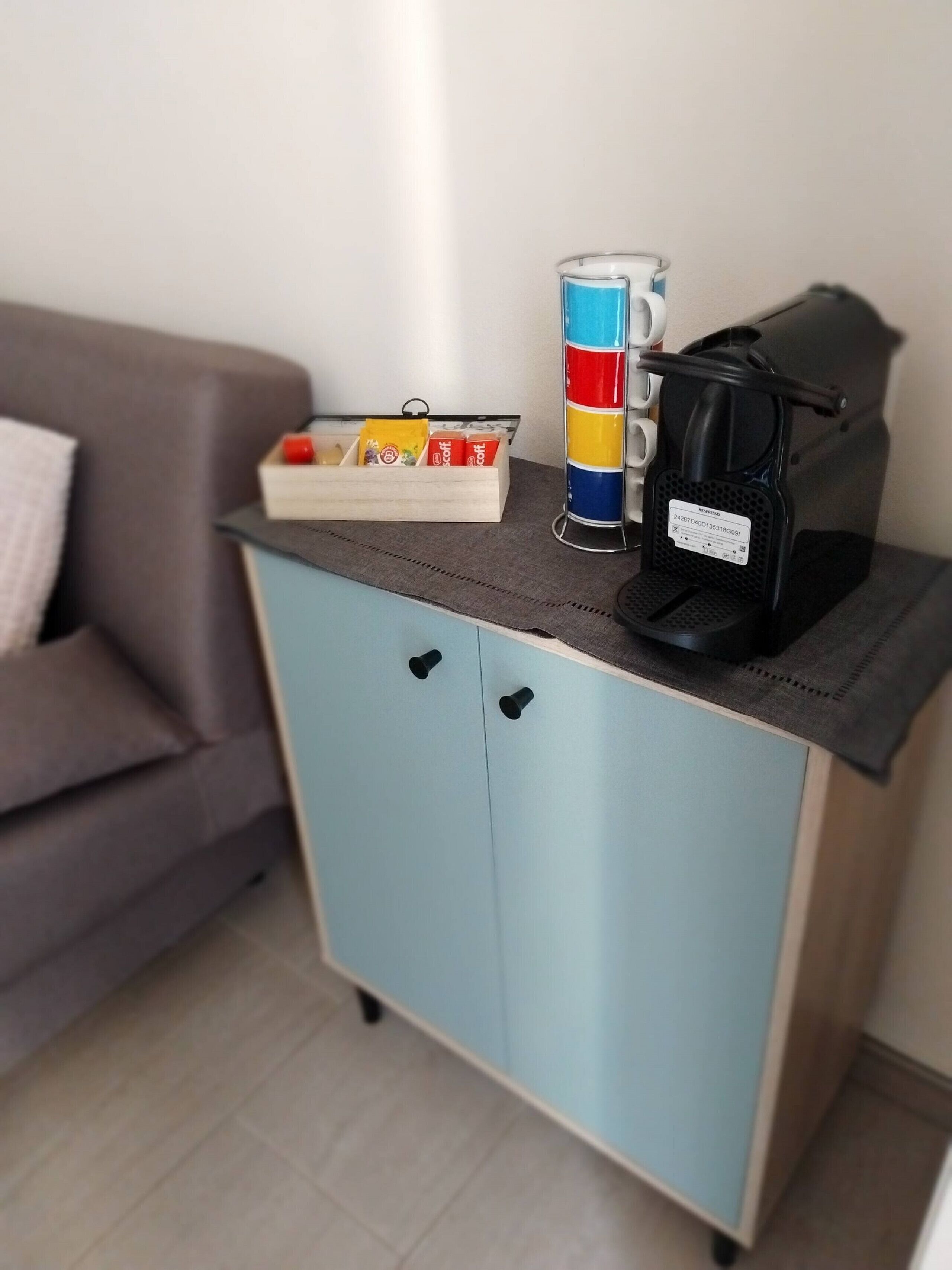 Pieni keittiönurkkaus, jossa on kahvinkeitin, muki ja tarjotinpäällinen pientä purtavaa.