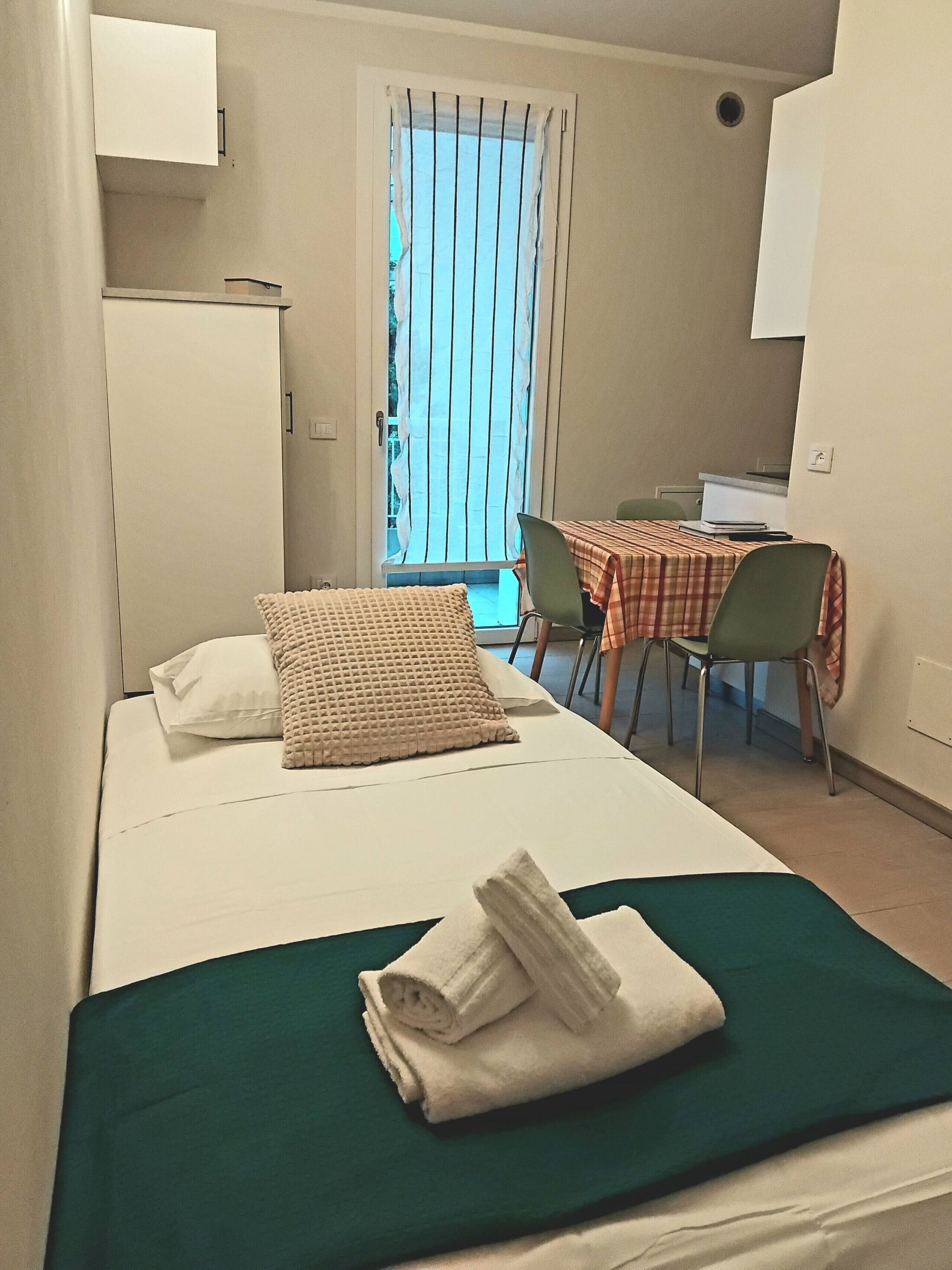Hotellihuone, jossa on sänky, työpöytä ja tuoli.