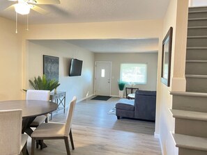 A living room with a dining table, sofa, and a staircase. - Long Stays Welcome! 3BR/1.5 bath (Rossford)