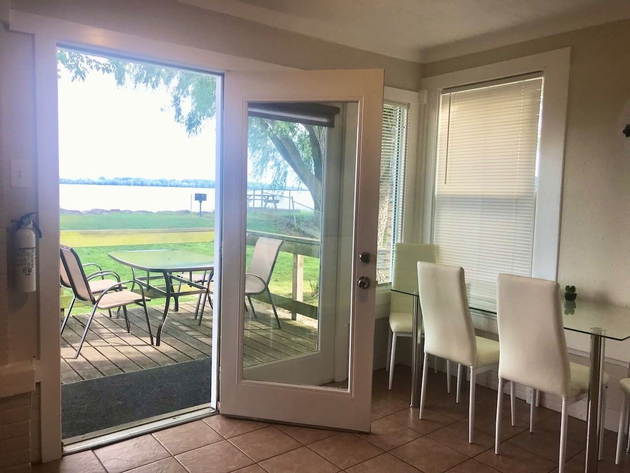 Une pièce dotée d’une porte-fenêtre coulissante donnant sur un patio extérieur avec une table et des chaises.