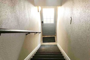 A stairway leading to a door with a window above it.