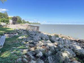 Une propriété au bord du lac, dotée d’un quai en bois, d’une table de pique-nique et d’un foyer.