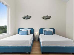 Un dormitorio con dos camas, una ventana y decoración en la pared.
