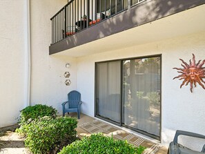 Ein Balkon mit Stuhl, Topfpflanzen und einer Zier-Sonne.