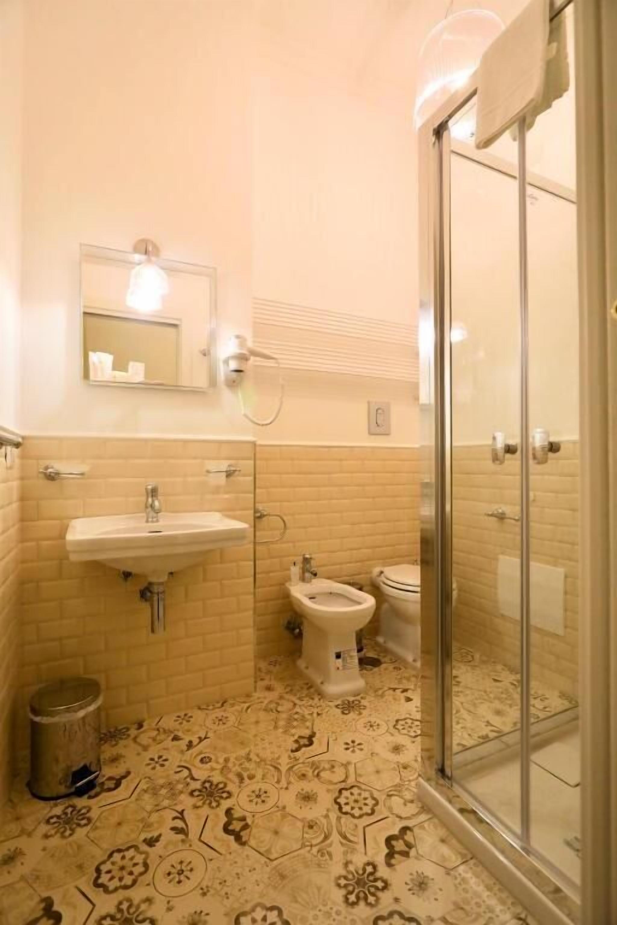 Un baño con lavamanos, inodoro y ducha.