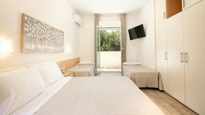A hotel room with a bed, two bedside tables, a flat-screen TV mounted on the wall, a wardrobe, and a sliding glass door leading to an outdoor area. - Hotel Bassetti (Cervia)