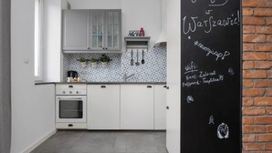 Eine moderne Küche mit weißen Schränken, einem eingebauten Backofen und einer Tafel mit Schrift.