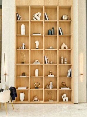 Ein mehrstufiges Holzregal mit verschiedenen Dekorationen und Büchern.
