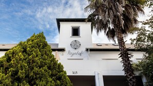 Un edificio con fachada blanca, ventana de marco negro y el número 165 visible.