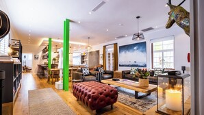 Una sala de estar moderna con chimenea, sofás de cuero, una mesa de centro y un ventanal grande.