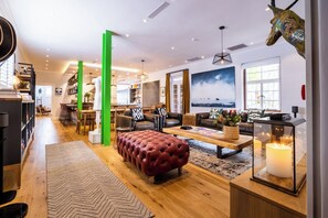 Ein modernes Wohnzimmer mit Kamin, Ledersofas, einem Couchtisch und einem großen Fenster.