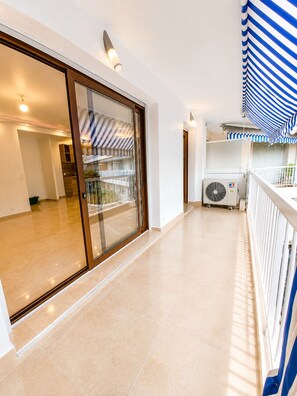 A modern interior with a glass door leading to a balcony, a ceiling fan, and a striped awning. - 3-room apartment in Cannes, 250 m from the beach. Close to all shops. 100-150 m (Cannes)