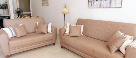 A living room with two sofas, a floor lamp, and a painting on the wall.