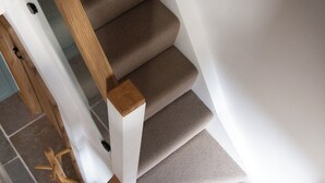 Eine Wendeltreppe mit Teppichstufen und Holzhandläufen.