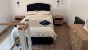 Ein Schlafzimmer mit Bett, Nachttischen, einem Schminktisch und einem Heizkörper.