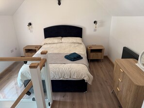 Ein Schlafzimmer mit Bett, Nachttischen, einem Schminktisch und einem Heizkörper.
