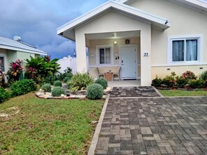 A residential building with a paved driveway, a front door, and a number '22' on the wall. - Your Jamaican Getaway | Summer Breeze Villa with Pool & Gym Access (Lucea)