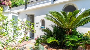 Un bâtiment blanc avec une porte, une fenêtre et un petit balcon.