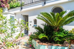 A white building with a door, a window, and a small balcony. - Naos Nerano - Elegance & Comfort (Nerano)