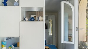 Une pièce avec une porte blanche, un miroir et une nappe bleue.