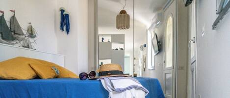 Una habitación con una cama, un sombrero, gafas de sol y una toalla sobre la cama.