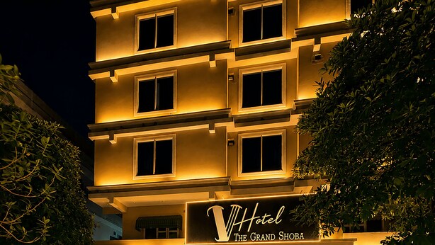 Et hotel med swimmingpool, flere etager og et skilt med teksten 'Hotel The Grand Shoha'.