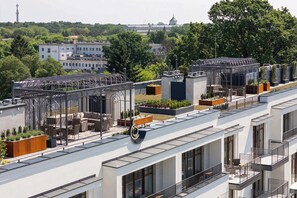 A modern building with multiple balconies, rooftop gardens, and a clear view of the surrounding cityscape. - Luxury Studio with Air Conditioning | Balcony | Roof Terrace (Ciechocinek)