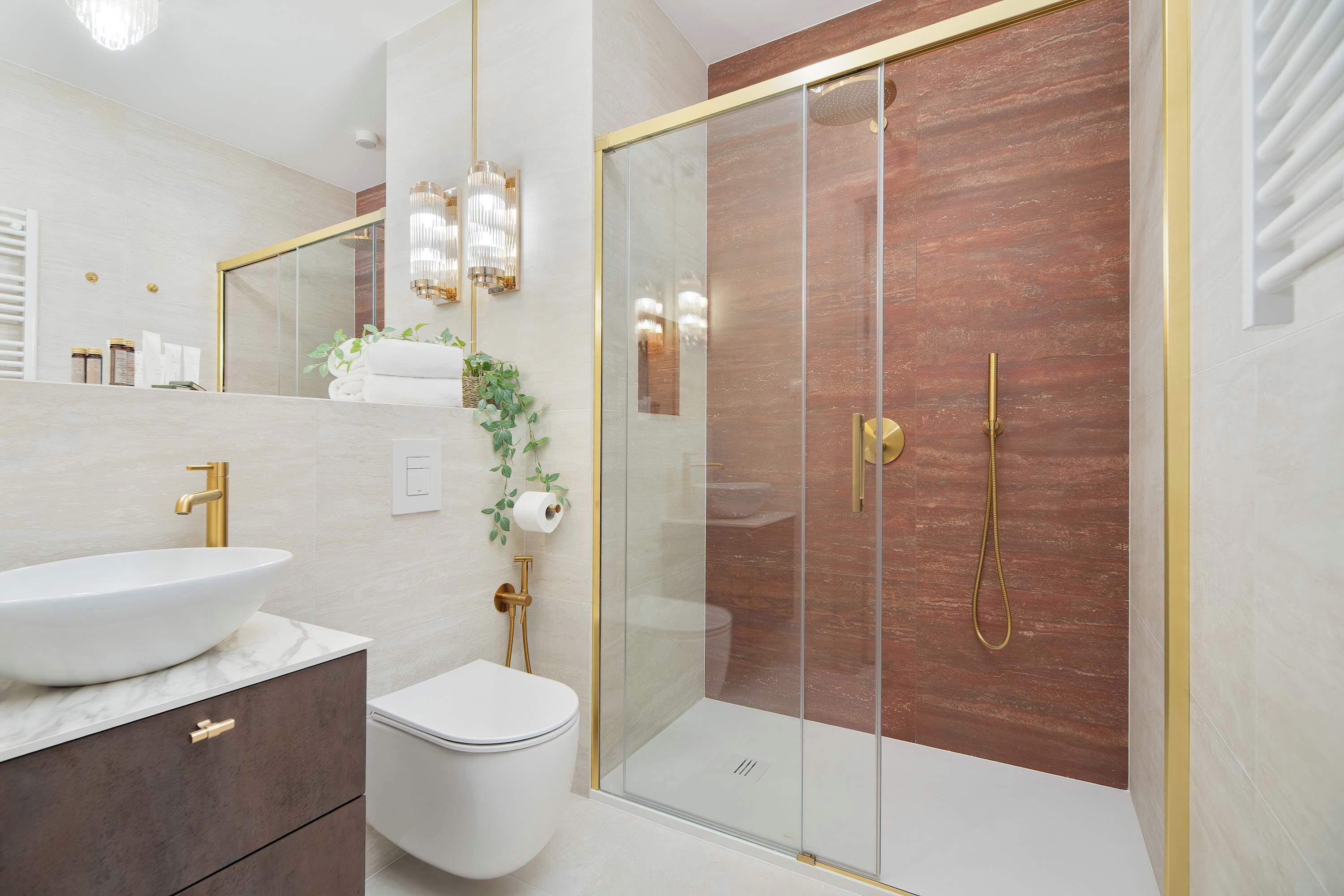A modern bathroom with a glass-enclosed shower, a white sink, and a toilet.