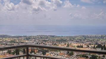 A residential area with buildings, a clear sky, and a distant view of the sea.