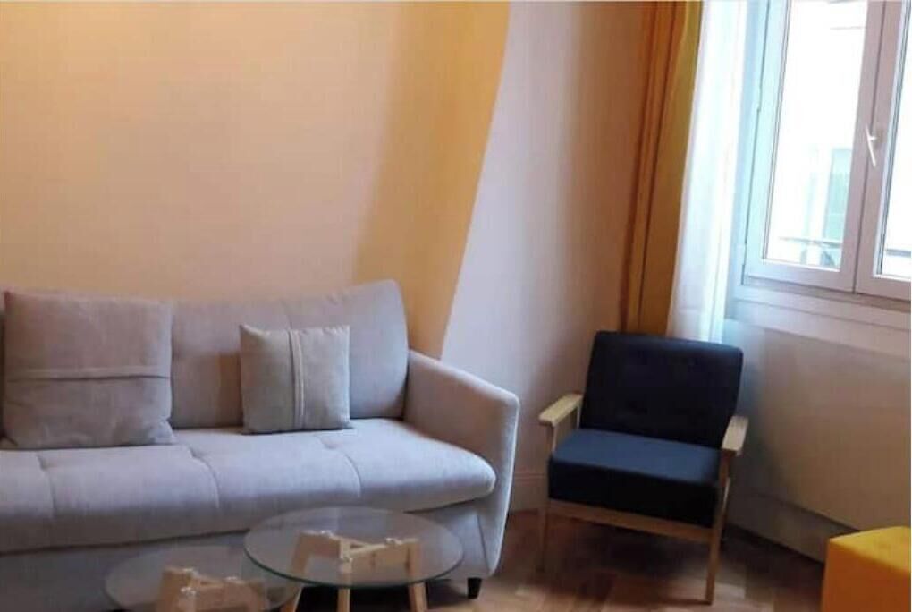 Uma sala de estar com um sofá, uma poltrona e uma mesa de centro.