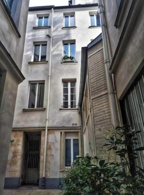 A multi-story building with a central entrance, windows on each floor, and a visible door. - Beautiful, Air-Conditioned Apartment in Aix, Right in the Heart of Downtown (ile de france)