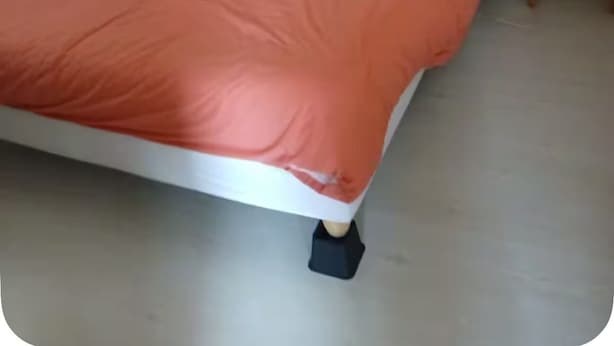 A room with a bed, a nightstand, and a wooden side table.
