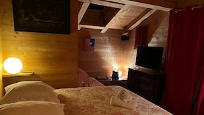 A room with a bed, a desk, a chair, a lamp, and a television. - The Red Room (Demi-Quartier)