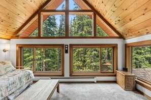 A bedroom with a large window, a bed, a bedside table, and a heater. - The Rendezvous Chalet – Spacious Mountain Retreat (Breckenridge)