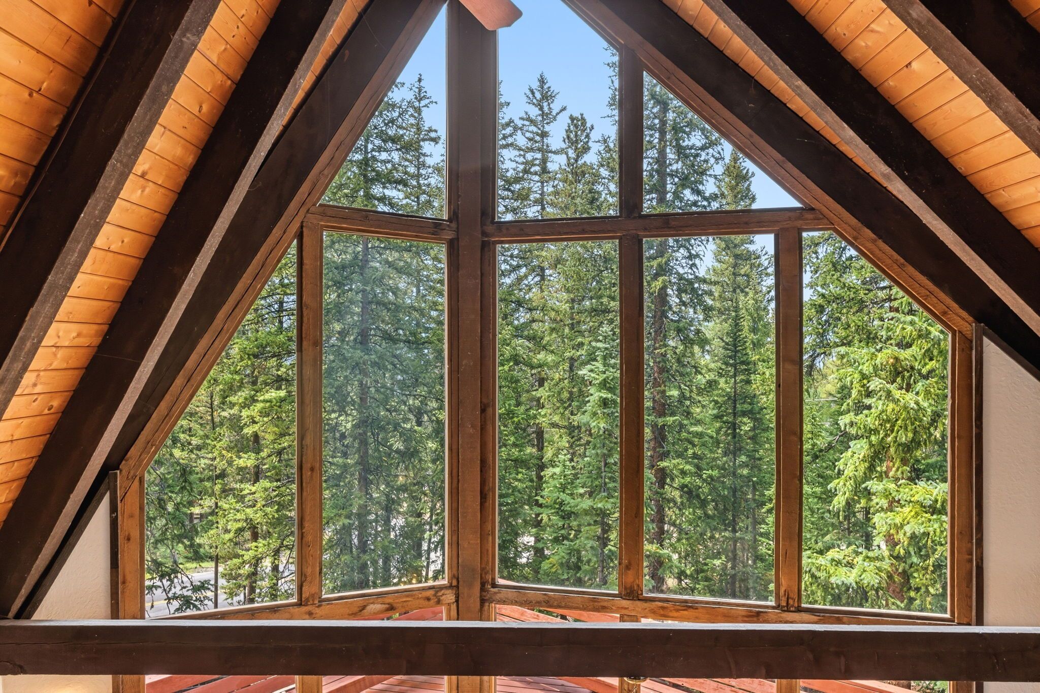 A room with a large window offering a view of a forest.
